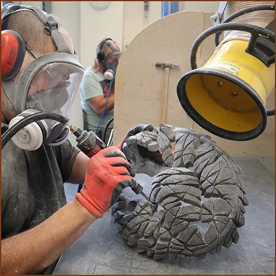 Picture showing a section of a Fox sculpture casting being fettled and finished with an air drill