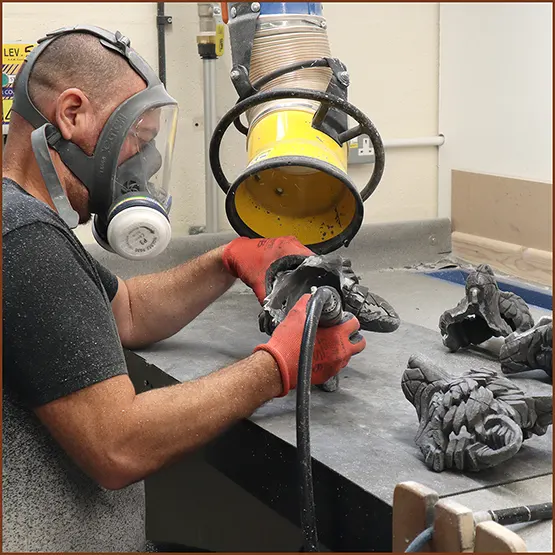 Picture showing a section of a Fox sculpture casting being fettled and finished with an air drill